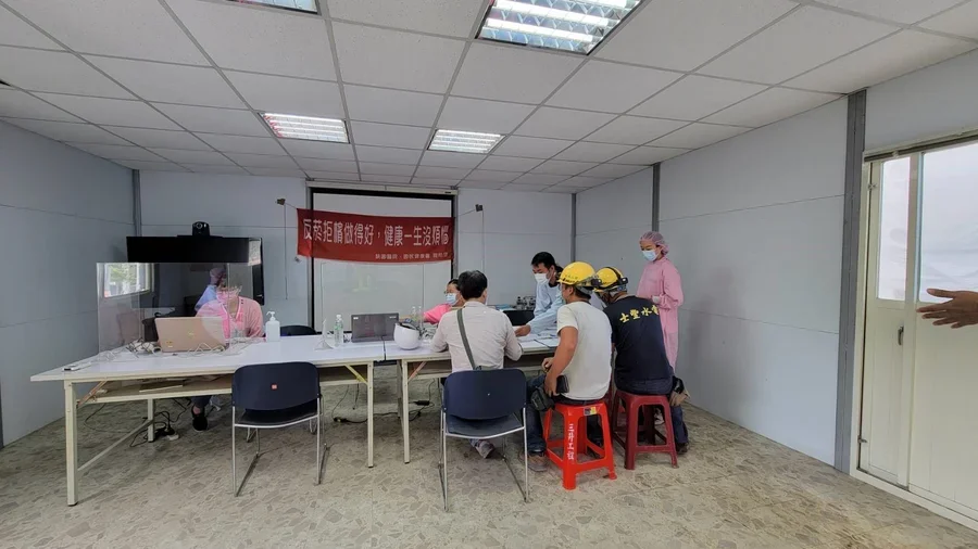 圖片說明：報到填寫資料等候篩檢。